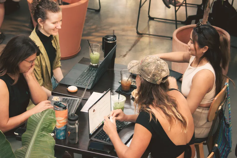 Four ATX Writing Club members working at one table