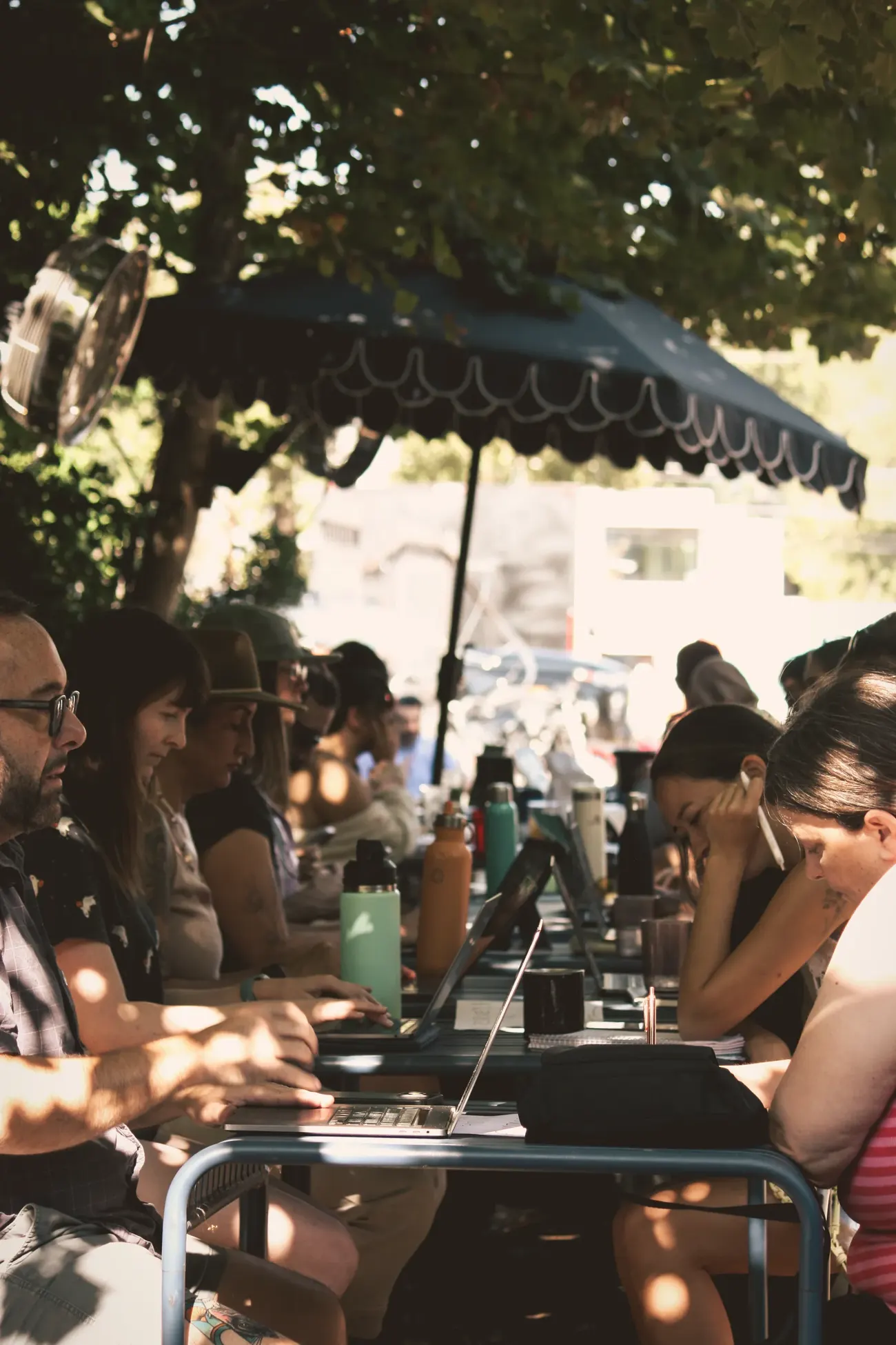A long table of ATX Writing Club members writing together outdoors in Austin