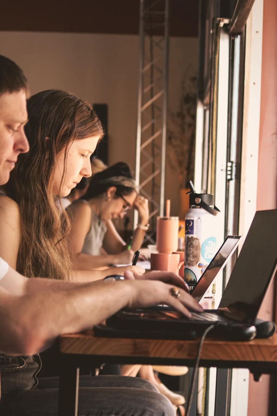Members writing side by side at a window bar