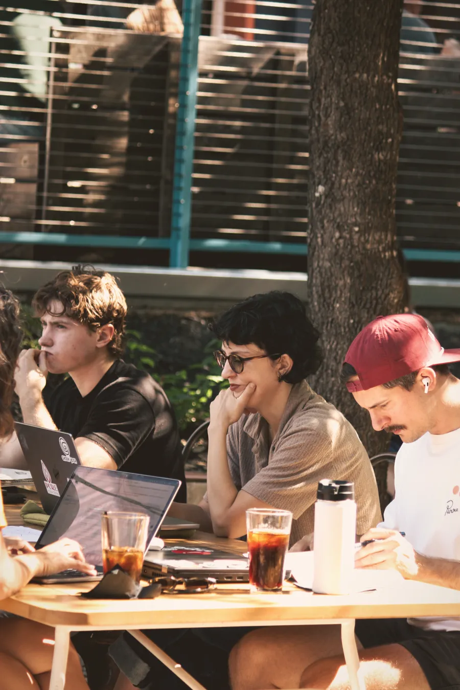 Four members talking around a table outdoors